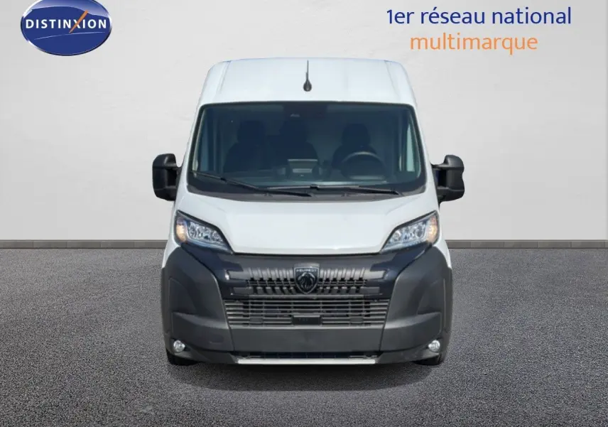 Vue frontale du Peugeot Boxer Fourgon blanc banquise, avec calandre noire et phares modernes allumés.