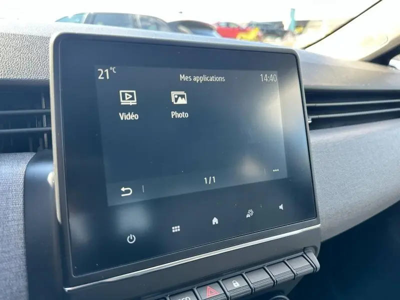 Écran tactile central de la Renault Clio 2025 gris Rafale, affichant les applications vidéo et photo, vue intérieure côté passager.