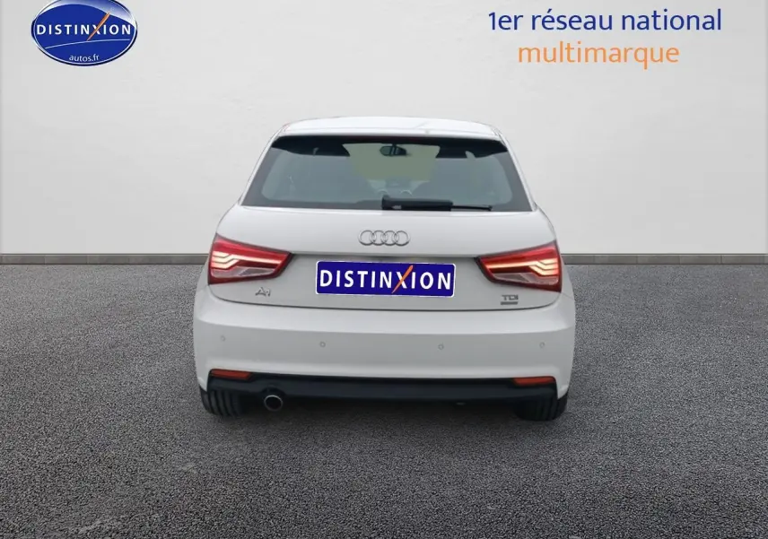 Vue arrière d'une Audi A1 blanche de 2015 avec feux LED et sortie d'échappement chromée visible côté gauche.