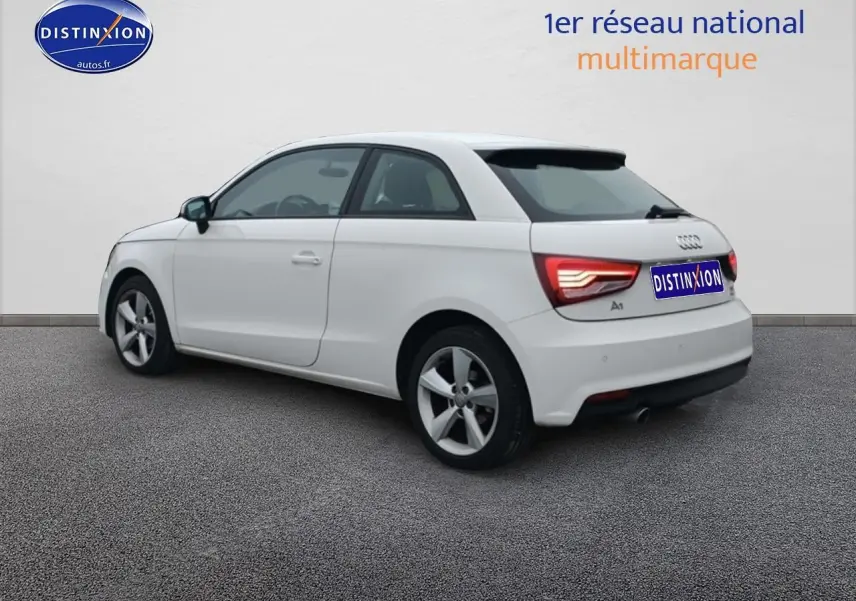 Audi A1 blanc vue 3/4 arrière côté gauche, feux arrière LED et jantes alliage visibles.