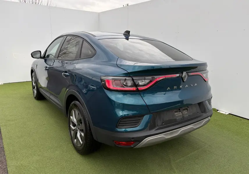 Vue 3/4 arrière droite d’un Renault Arkana bleu Zanzibar métallisé avec feux arrière LED et vitres surteintées.