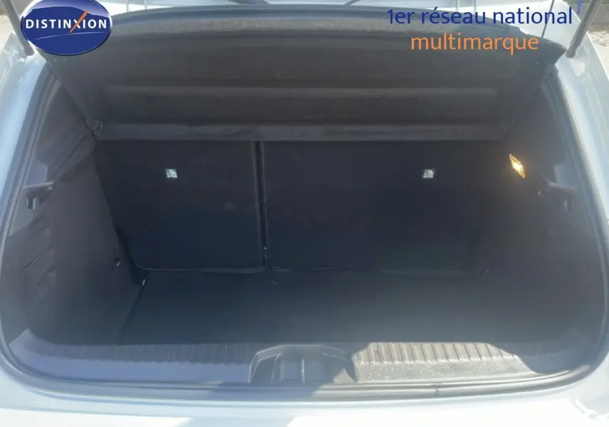 Coffre ouvert d'une Renault Clio blanche 2025, vue arrière montrant l'espace de chargement vide et l'éclairage intérieur.