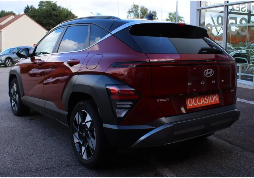 Vue 3/4 arrière droite du Hyundai Kona 2024 rouge Ultimate Metal avec toit noir et jantes alliage 17 pouces.