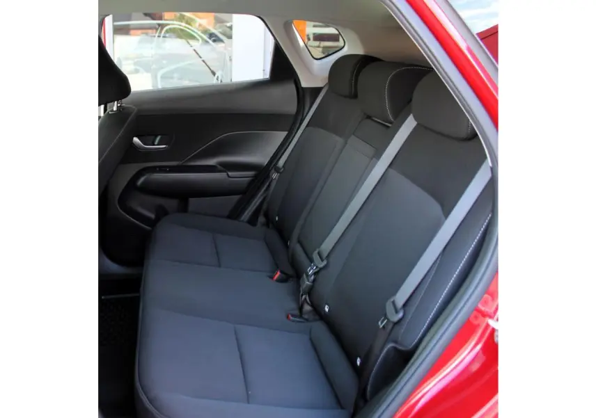 Vue intérieure côté gauche des sièges arrière noirs du Hyundai Kona rouge Ultimate Metal 2024 avec ceinture grise.