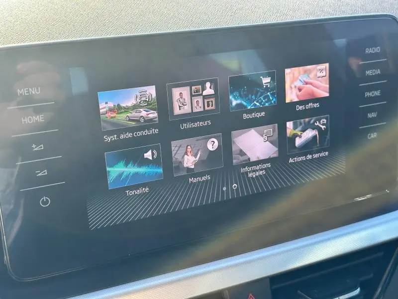 Écran tactile multimédia du Skoda Kamiq 2020 affichant les options de menu et d'aide à la conduite.