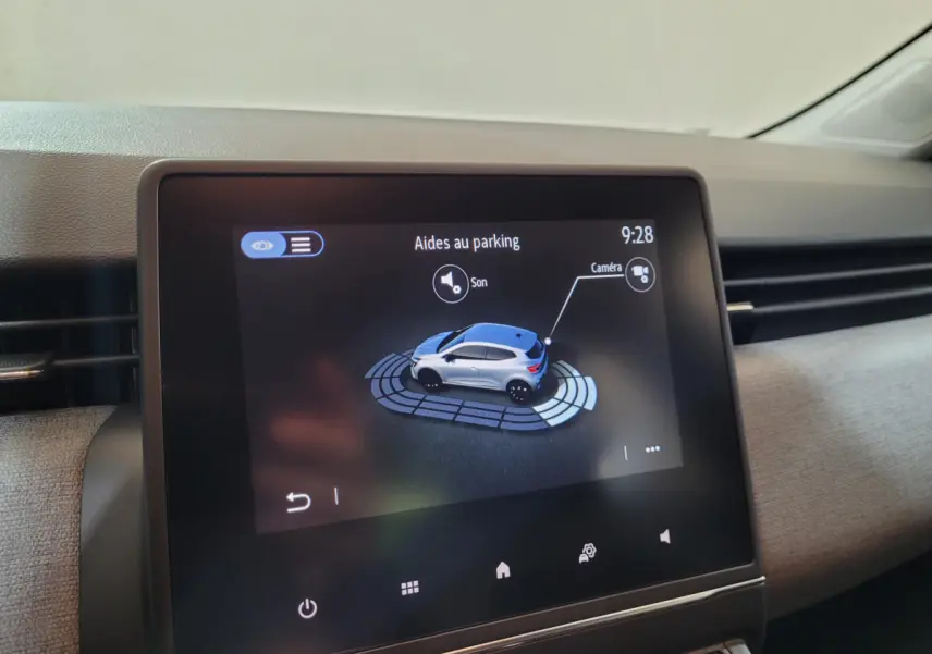 Écran tactile central montrant l'aide au stationnement avec vue 3D du véhicule gris côté droit, intérieur Renault Clio 2025.