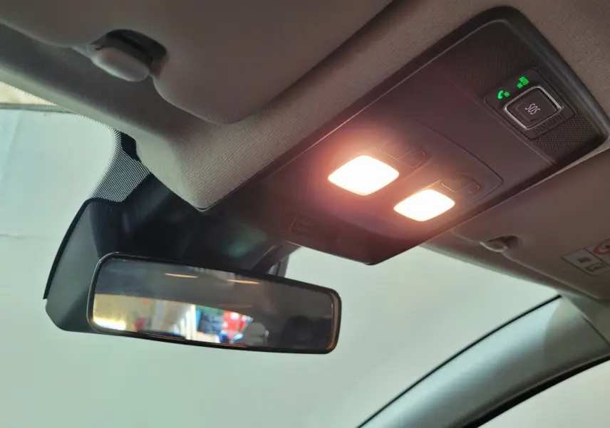 Vue intérieure du rétroviseur central et du plafonnier avec éclairage allumé dans une Renault Clio gris foncé de 2025.