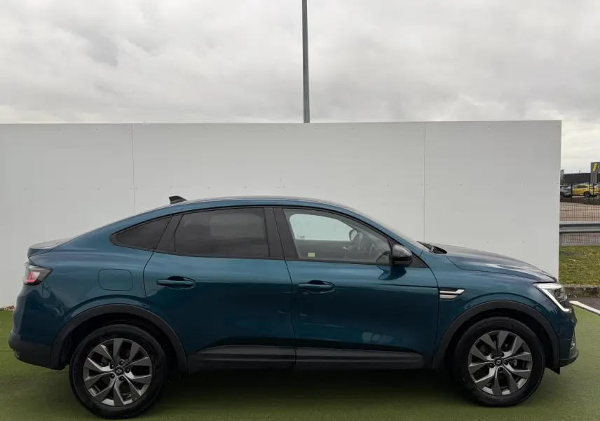 Profil droit du Renault Arkana 2025 bleu Zanzibar métallisé avec vitres surteintées et jantes alliage grises 17 pouces.