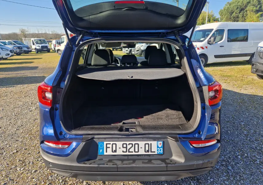 Vue arrière d’un Renault Kadjar bleu cosmos 2020 avec coffre ouvert montrant l’espace de chargement vide.