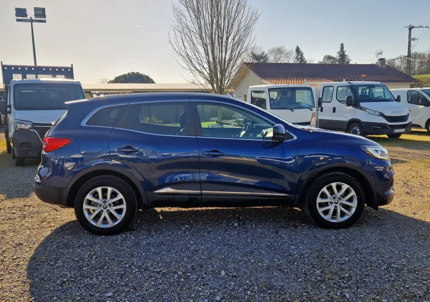 Profil côté gauche d’un Renault Kadjar 1.5 Blue dCi 115 Business bleu cosmos, avec jantes alliage et toit lisse.