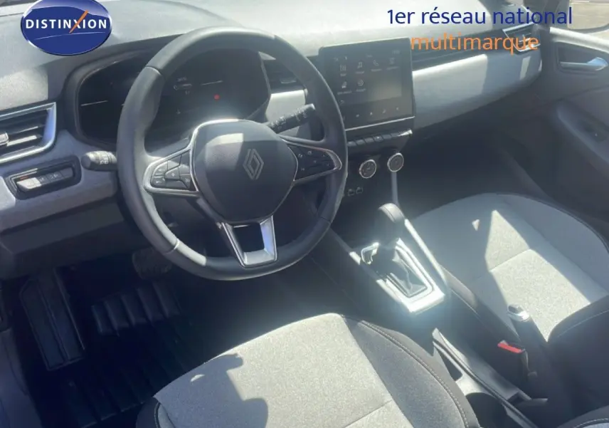 Vue intérieure de la Renault Clio 2025, montrant le poste de conduite avec volant multifonction et écran tactile central.
