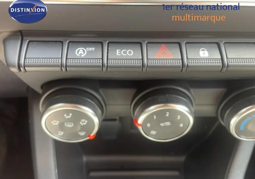 Gros plan sur les commandes de climatisation et boutons fonctionnels du tableau de bord d'une Renault Clio blanche 2025.