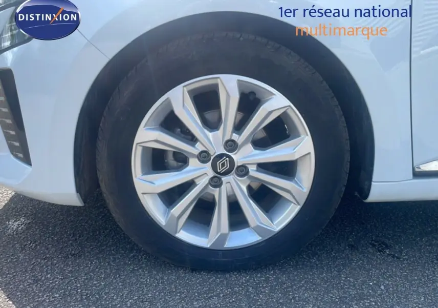 Gros plan sur la roue avant droite de la Renault Clio blanche 2025 avec jante alliage argentée au design moderne.