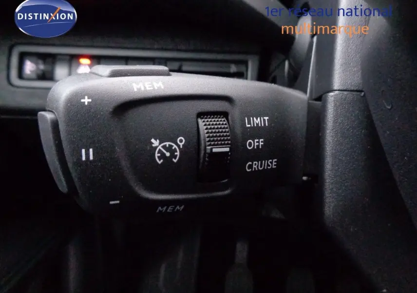 Commande de régulateur de vitesse sur le volant d'un Peugeot 3008 gris Artense 2023, vue intérieure rapprochée.