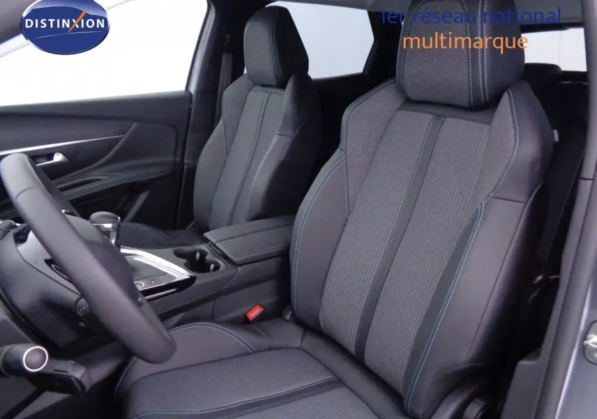 Intérieur du Peugeot 3008 2023, vue côté conducteur, sièges en cuir noir avec surpiqûres bleues et tissu gris.