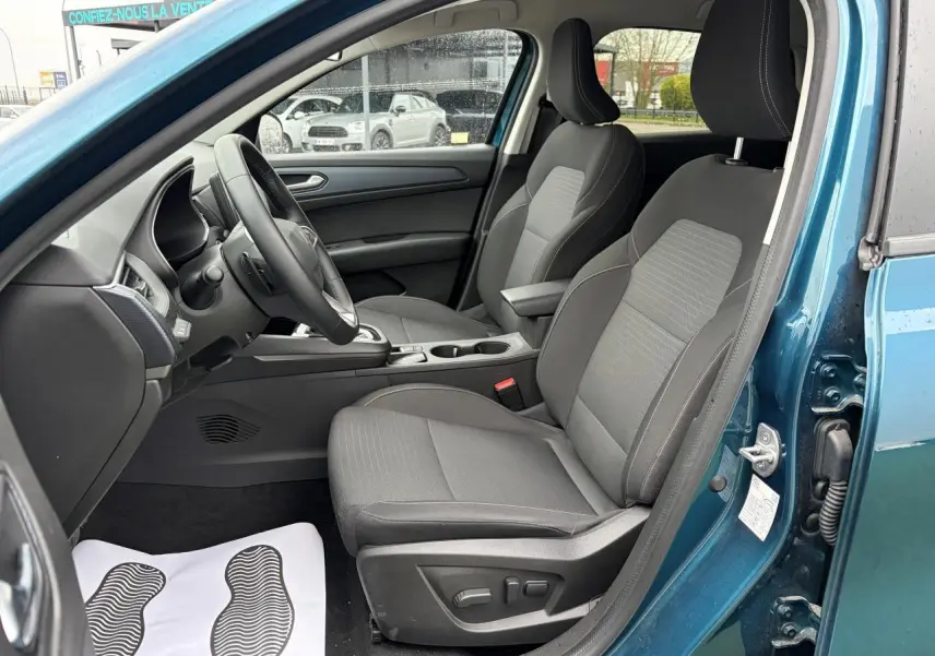 Vue intérieure côté conducteur de la Renault Arkana bleu Zanzibar, sièges tissu gris avec réglages électriques visibles.