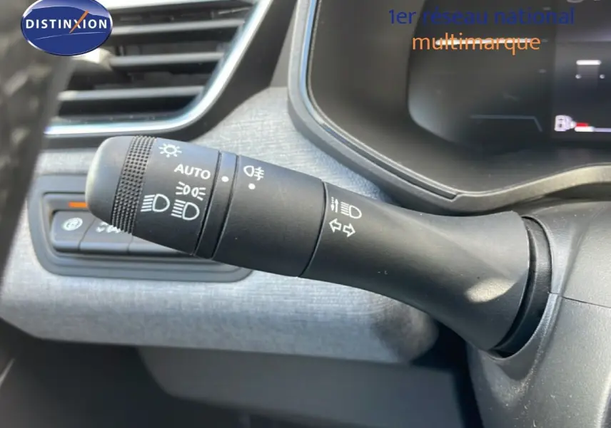 Gros plan sur la commande des phares et clignotants dans l’habitacle d’une Renault Clio gris schiste métal 2025.