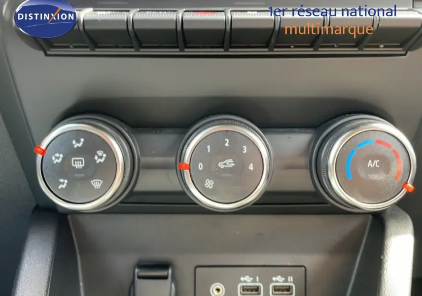 Gros plan sur les commandes de climatisation et les ports USB d’une Renault Clio gris schiste, intérieur moderne.