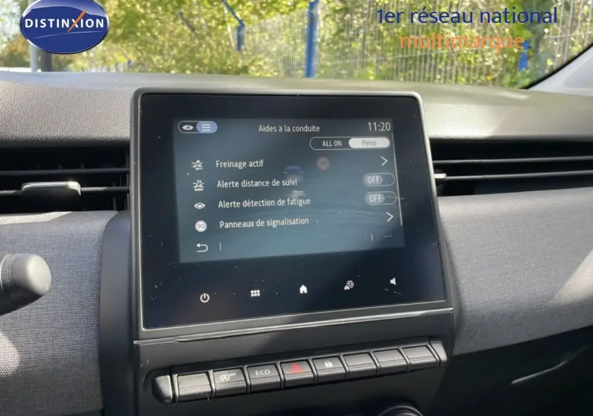 Vue rapprochée de l’écran tactile central du tableau de bord de la Renault Clio gris schiste, affichant les aides à la conduite.