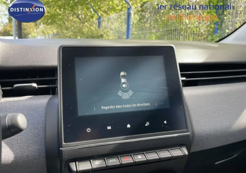 Tableau de bord de Renault Clio 2025, écran tactile central affichant une alerte de sécurité, ambiance intérieure grise.