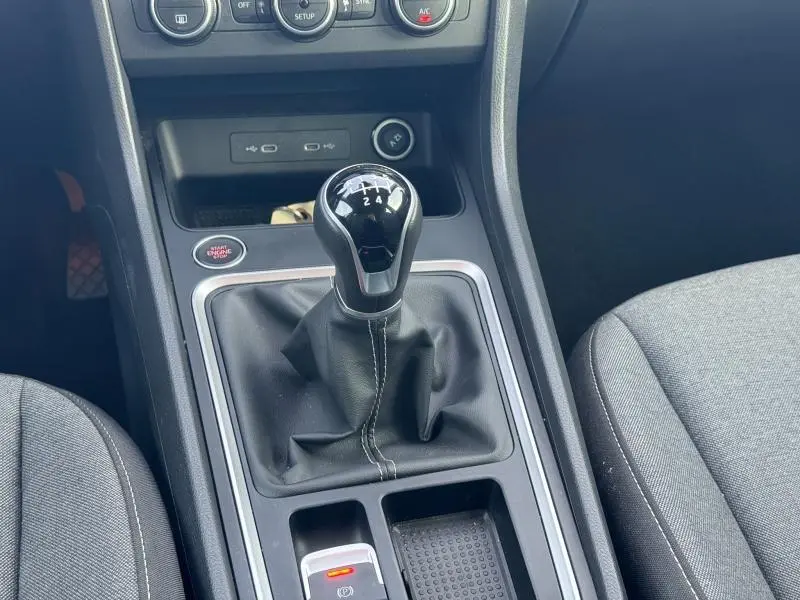 Levier de vitesse manuel noir avec coutures blanches au centre de la console d’un SEAT Ateca 2024, intérieur gris.