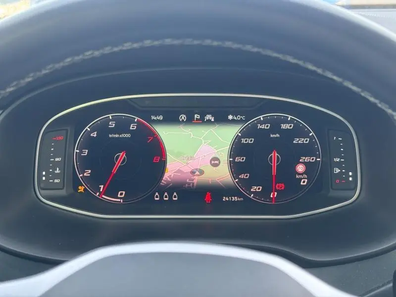 Vue rapprochée du tableau de bord numérique du SEAT Ateca 2024, affichant la carte GPS et compteurs ronds noirs.