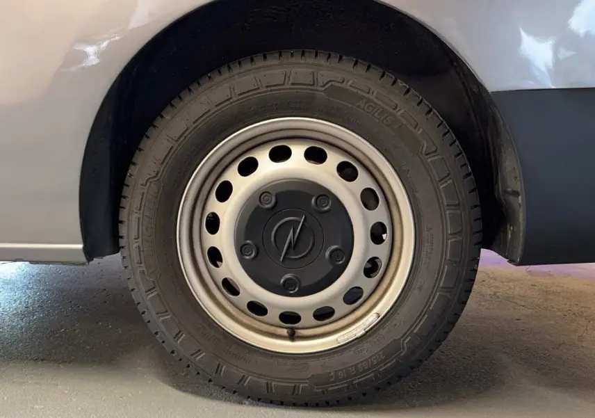 Gros plan sur la roue avant droite grise d'un Opel Vivaro Combi 1.5 Diesel 120 de 2022 avec jante acier.