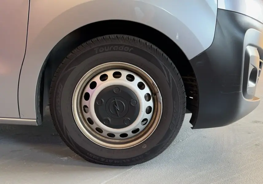 Gros plan sur la roue avant droite grise d'un Opel Vivaro Combi 1.5 Diesel 120 de 2022 avec jante acier.