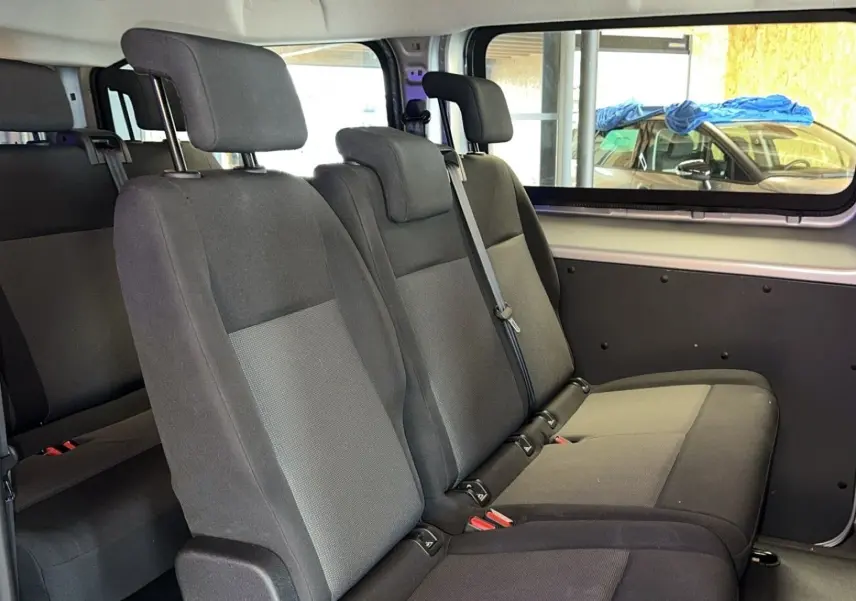 Vue intérieure des sièges en tissu gris foncé et clair à trois places du côté droit de l'Opel Vivaro Combi gris 2022.