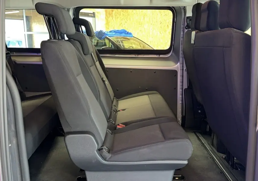 Vue latérale intérieure des sièges en tissu noir du côté gauche de l'Opel Vivaro Combi gris Diesel 2022.