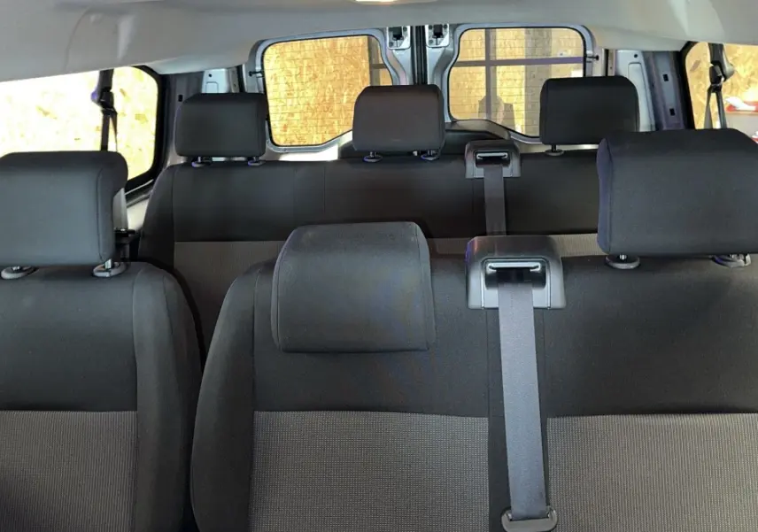 Vue intérieure des sièges en tissu noir et gris de l'Opel Vivaro Combi 2022, version diesel 1.5, avec ceintures visibles.