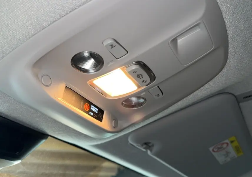 Plafonnier intérieur allumé avec indicateur d'airbag dans un Opel Vivaro Combi gris 2022, vue en légère contre-plongée.