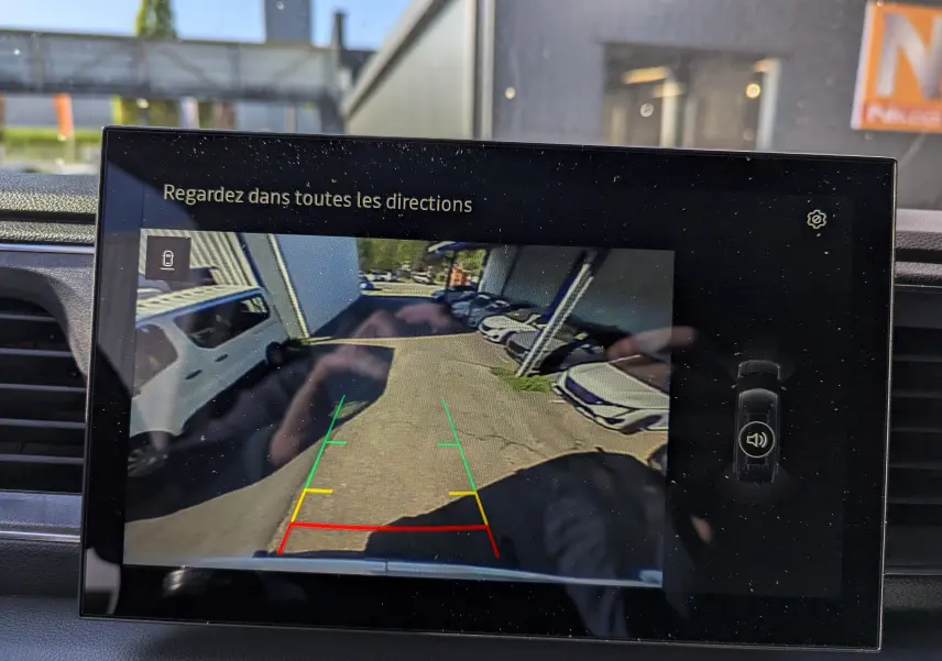 Écran de caméra de recul montrant l'arrière du Renault Master blanc L2H2 avec lignes de guidage colorées.