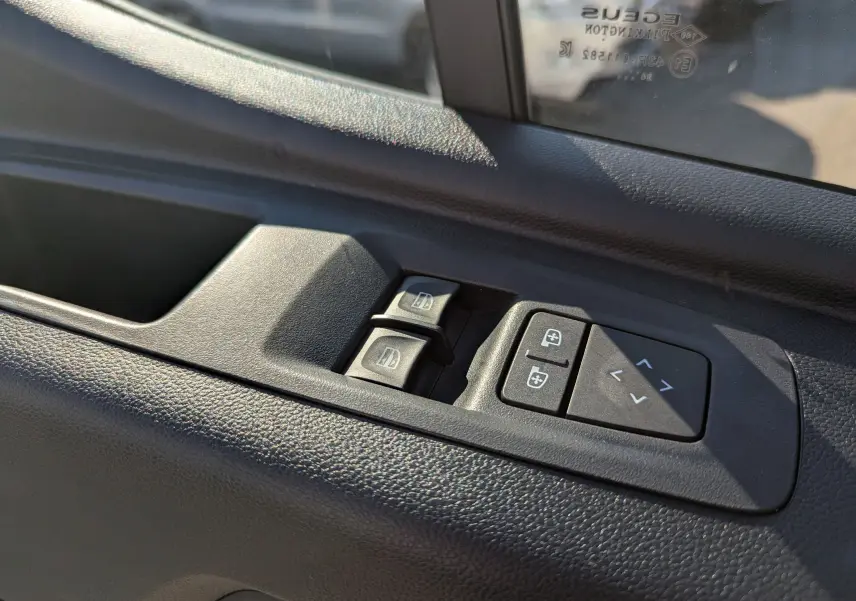 Commandes électriques des vitres et rétroviseurs sur la porte côté conducteur d'un Renault Master blanc 2025.