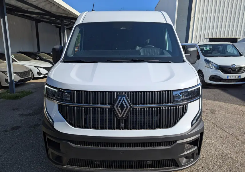 Vue frontale d'un utilitaire Renault Master blanc 2025 avec calandre noire et grand logo central.