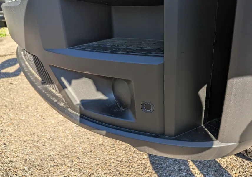 Gros plan sur le pare-chocs avant noir du Renault Master blanc, mettant en valeur le capteur de recul intégré.