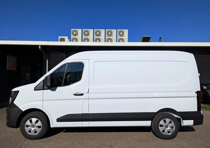 Vue latérale côté gauche d’un Renault Master blanc L2H2 2025 avec bande noire et jantes argentées.