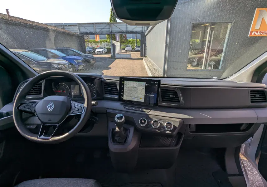 Intérieur du Renault Master 2025, vue frontale du tableau de bord avec écran tactile et levier de vitesses manuel.