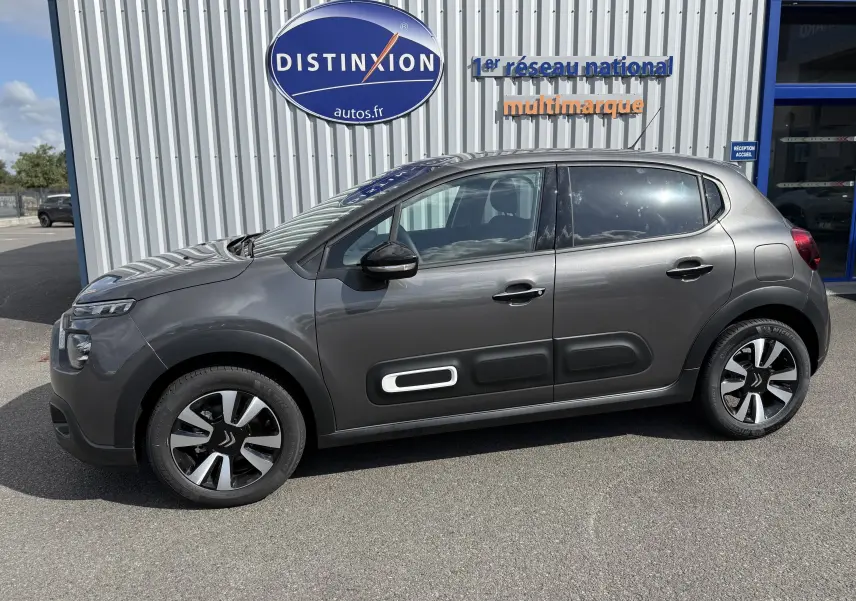 Citroën C3 gris platinium vue de profil côté gauche, avec protections latérales noires et jantes alliage bicolores.