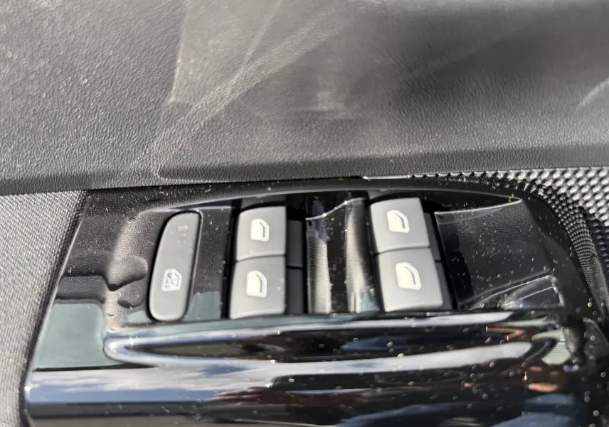 Boutons de commande des vitres électriques côté gauche intérieur d'une Citroën C3 gris platinium 2024.