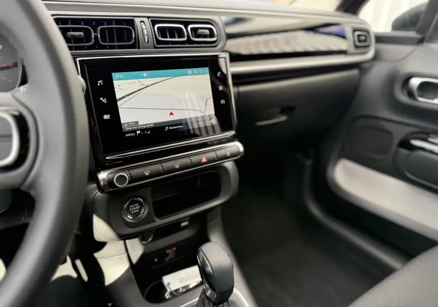 Vue intérieure côté passager du tableau de bord et écran tactile de la Citroën C3 gris platinium 2024 avec boîte auto.