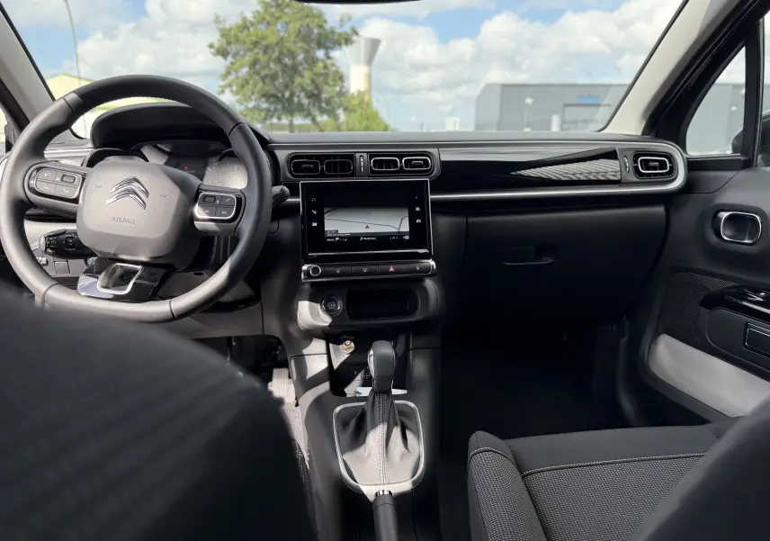Intérieur de la Citroën C3 2024 gris platinium, vue frontale sur le tableau de bord et la console centrale avec écran tactile.