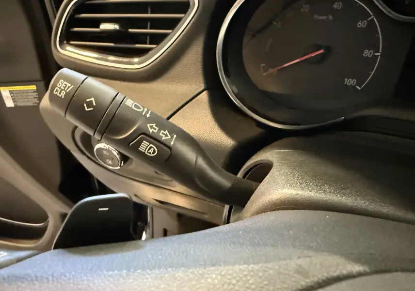 Gros plan sur la commande de clignotant à gauche du volant dans l'habitacle noir de l'Opel Grandland X hybride 2021.