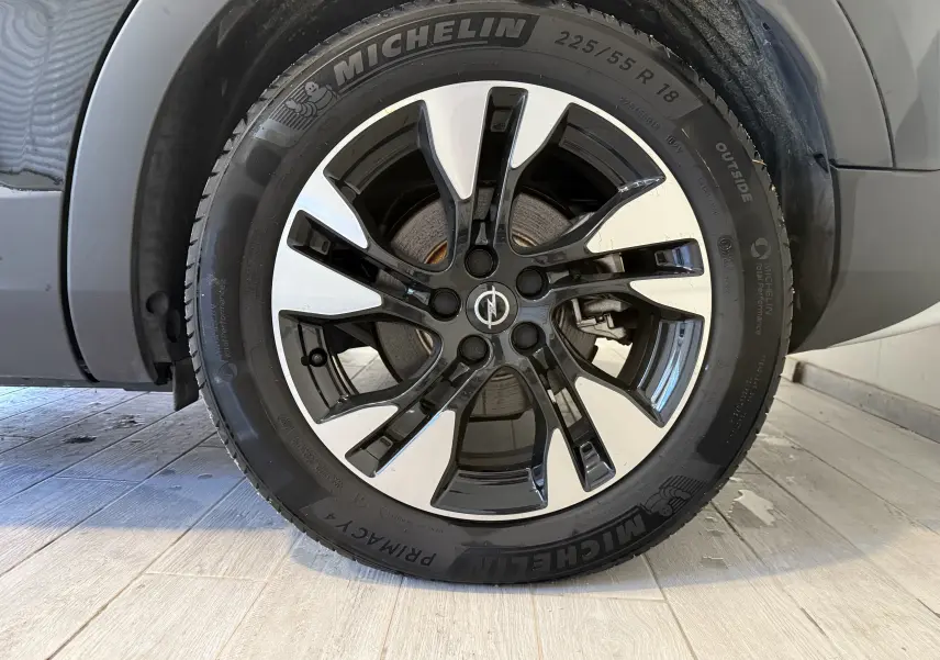 Gros plan sur la roue avant droite de l'Opel Grandland X noir métal, jante alliage bicolore et pneu Michelin.