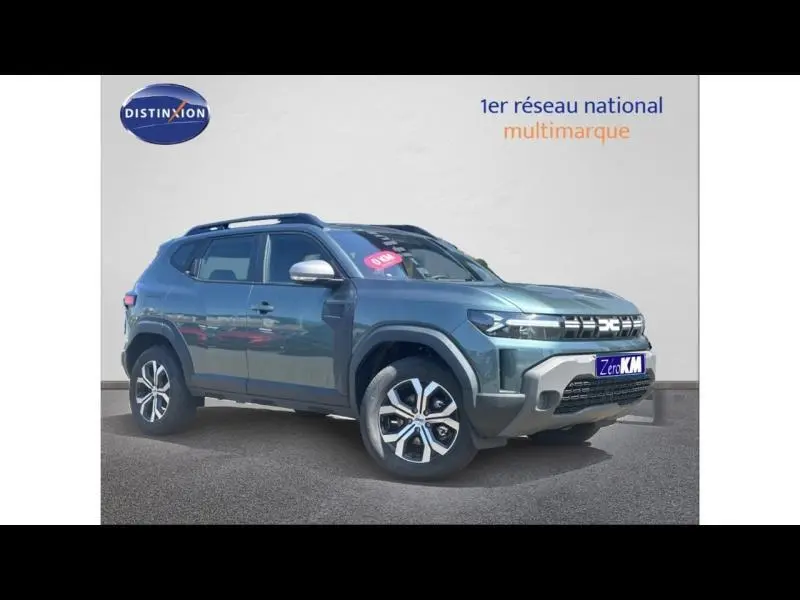 Vue 3/4 avant droite d'un Dacia Duster bleu métallisé avec jantes alu et barres de toit sur fond neutre.