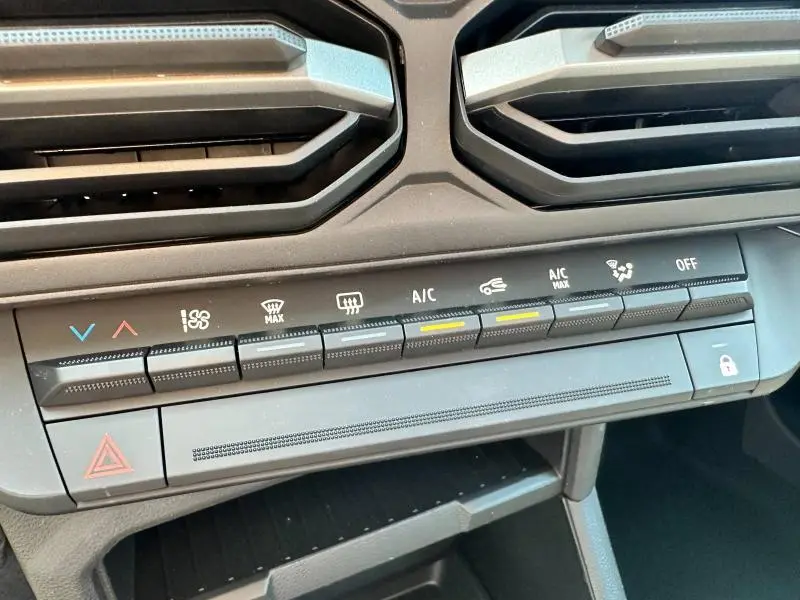 Détail des commandes de climatisation et ventilation du tableau de bord du Dacia Duster blanc 2025.