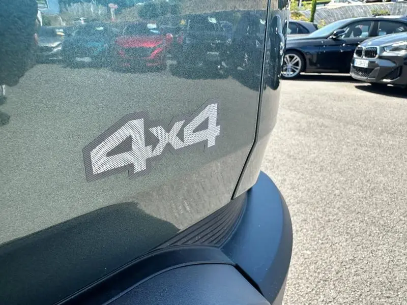 Gros plan sur l'arrière droit d'un Dacia Duster gris avec logo 4x4 visible sur le coffre.