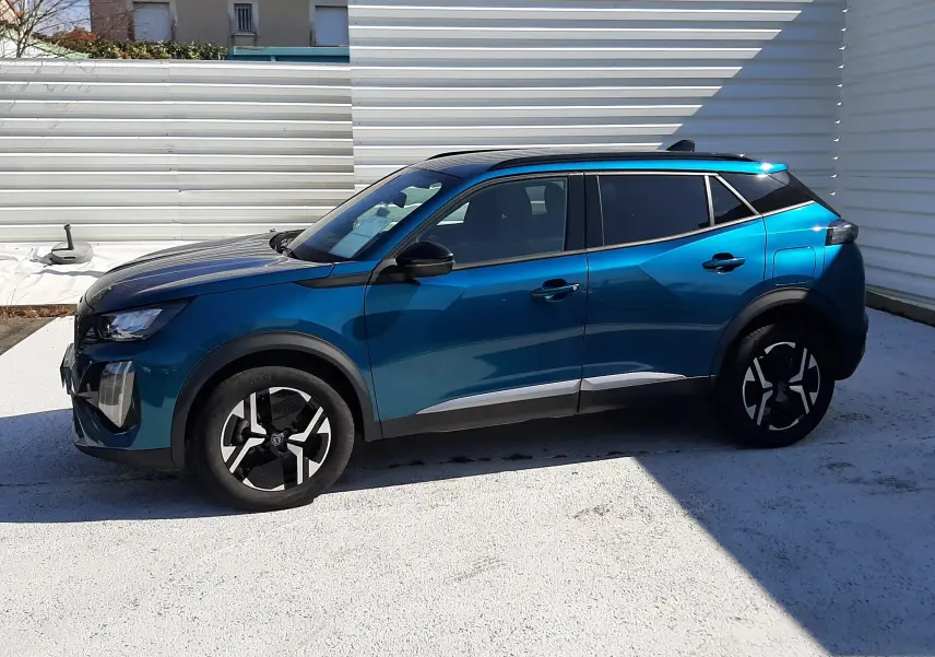 Peugeot 2008 Hybrid 145 Allure en bleu obsession, vue de profil côté gauche, avec toit noir et jantes bicolores.