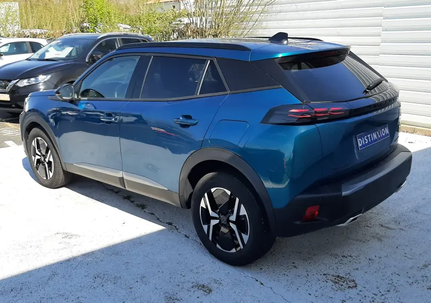 Peugeot 2008 Hybrid 145 Allure bleu obsession vue 3/4 arrière droit, toit noir et jantes bi-ton distinctives.