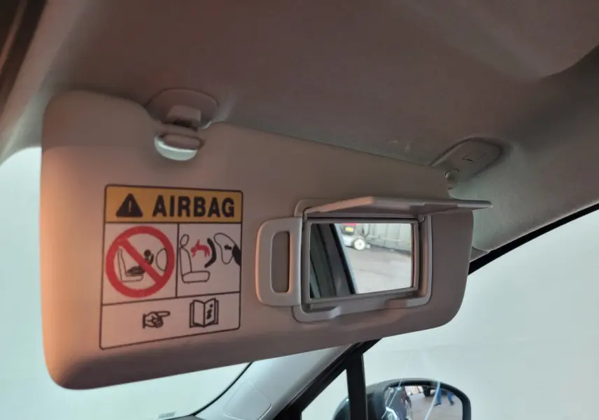 Détail du pare-soleil côté conducteur avec miroir intégré dans une Renault Clio gris foncé, vue intérieure avant gauche.